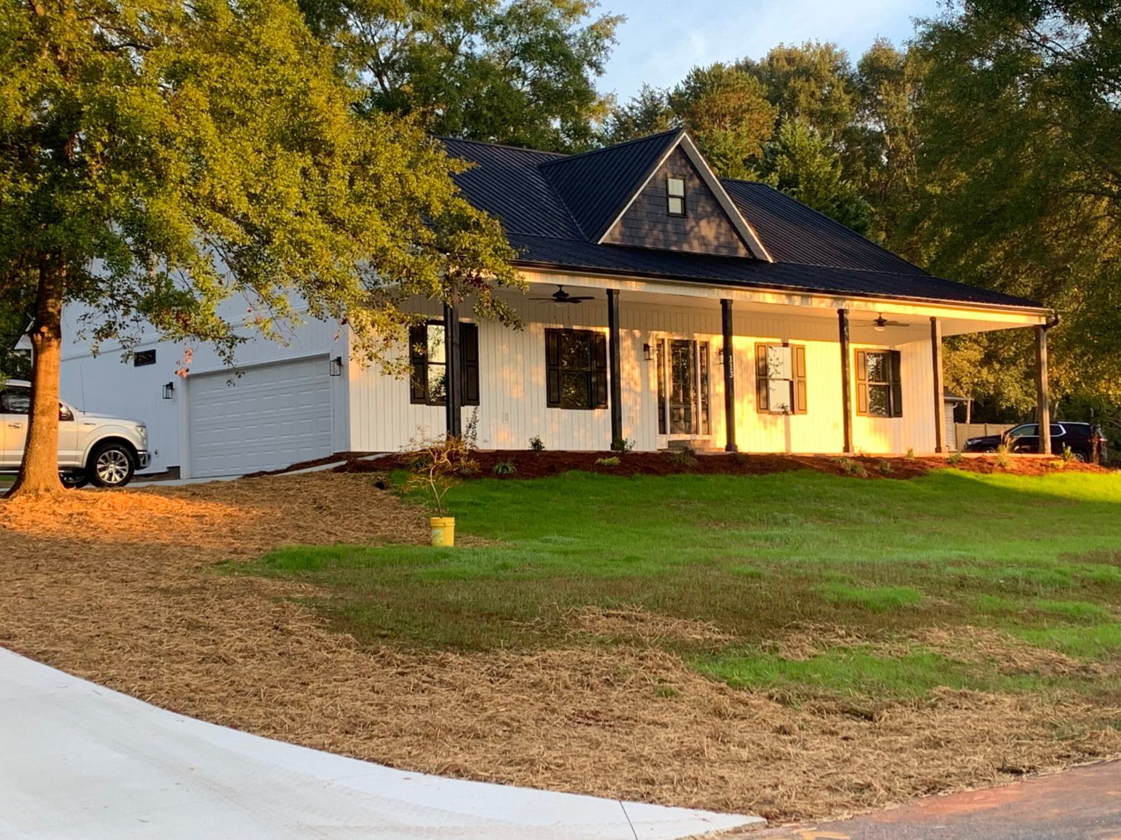 White board-and-batten siding on a modern farmhouse with a wraparound porch